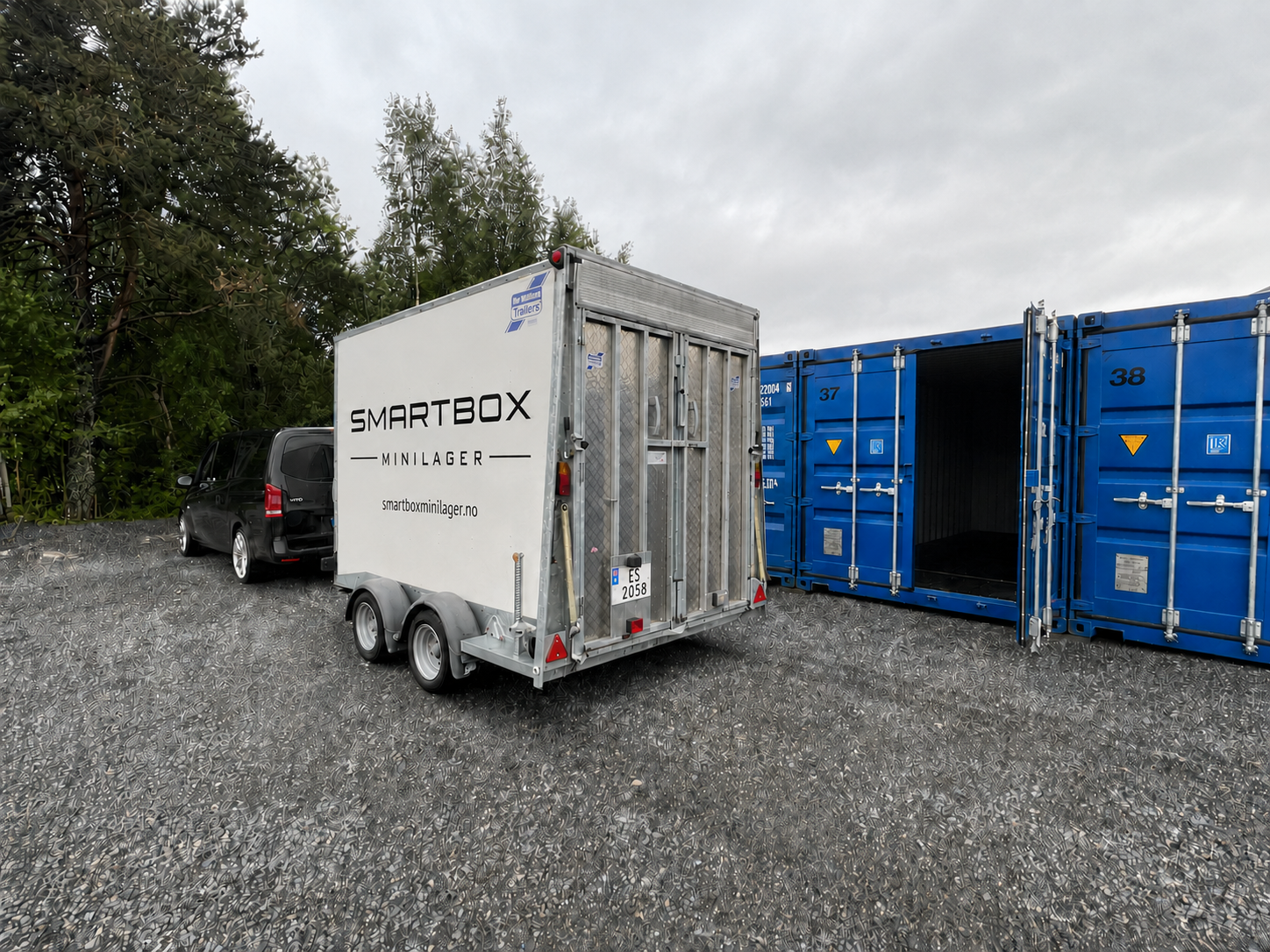 Bil med profilert SmartBox Minilager-tilhenger kjørt helt frem til lagercontainerne på Skodje